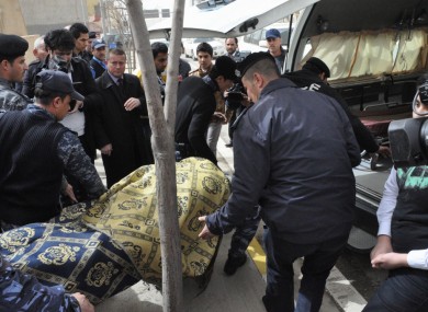 The body of the slain American gym teacher is carried out of the school in Sulaimaniyah