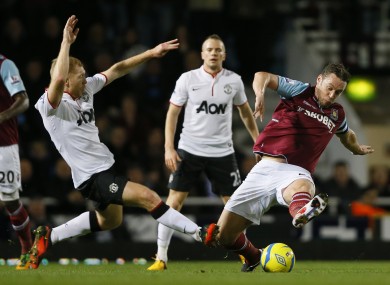 Paul Scholes and Kevin Nolan compete for the ball.