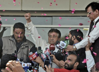 Musharraf, centre, gestures to his supporters, unseen, upon his arrival to Karachi airport