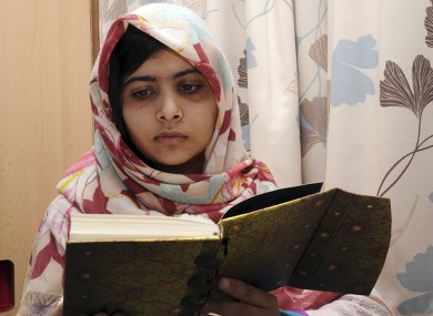Malala Yousafzai reading a book while in hospital