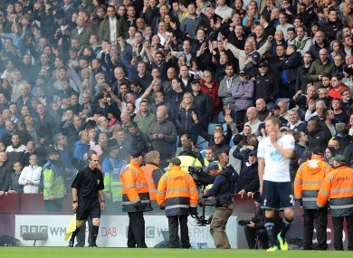 Assistant referee David Bryan on the touchline after being hit by a flare.