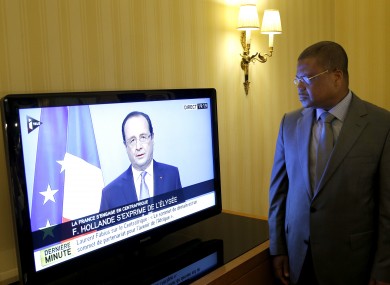 Prime Minister of the Central African Republic Nicolas Tiangaye watches French President Francois Hollande on TV