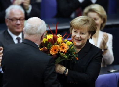 German Chancellor Angela Merkel receives flowers from well-wishers this morning.