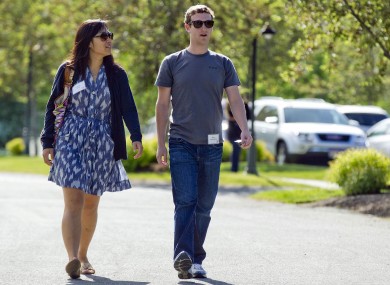 Mark Zuckerberg, president and CEO of Facebook, walks with Priscilla Chan